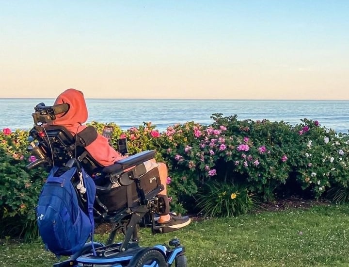 a person in a wheelchair in a garden with ocean views