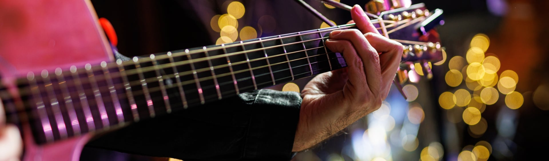 Musicians playing acoustic guitar, close up