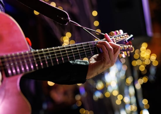 Musicians playing acoustic guitar, close up