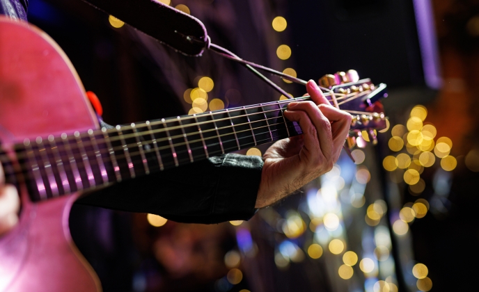 Musicians playing acoustic guitar, close up