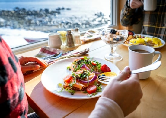 a couple eating breakfast with an ocean view