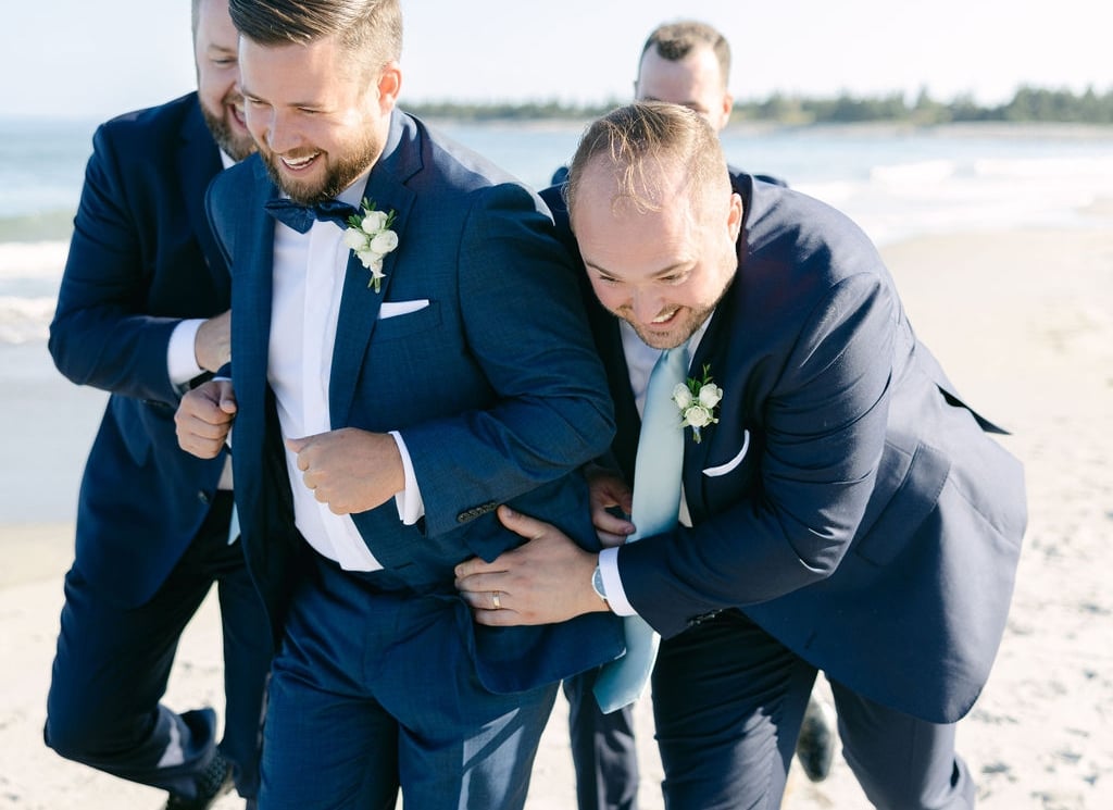 groom and grooms men on a beach
