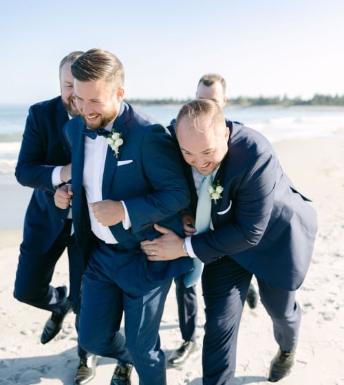 groom and grooms men on a beach